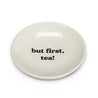 small white dish with bold black writing that says 'but first, tea!' on white background