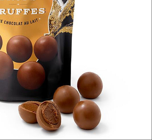 Bag of Roger & Chocolat truffle drops with chocolate truffles on a white background