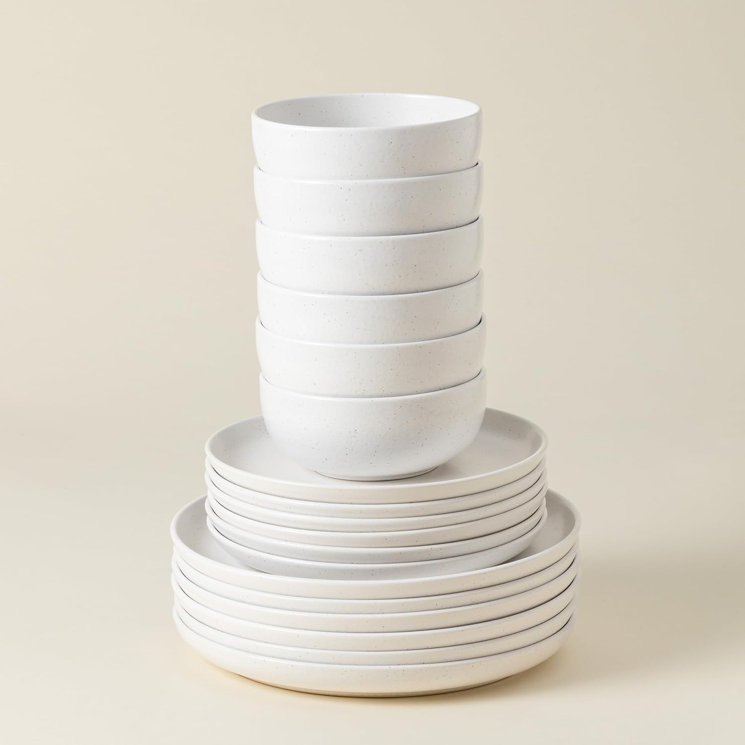 Stack of white ceramic bowls on a beige background