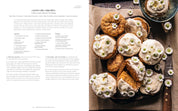 Carrot cake cupcakes with cream cheese frosting on a tray, alongside a recipe.