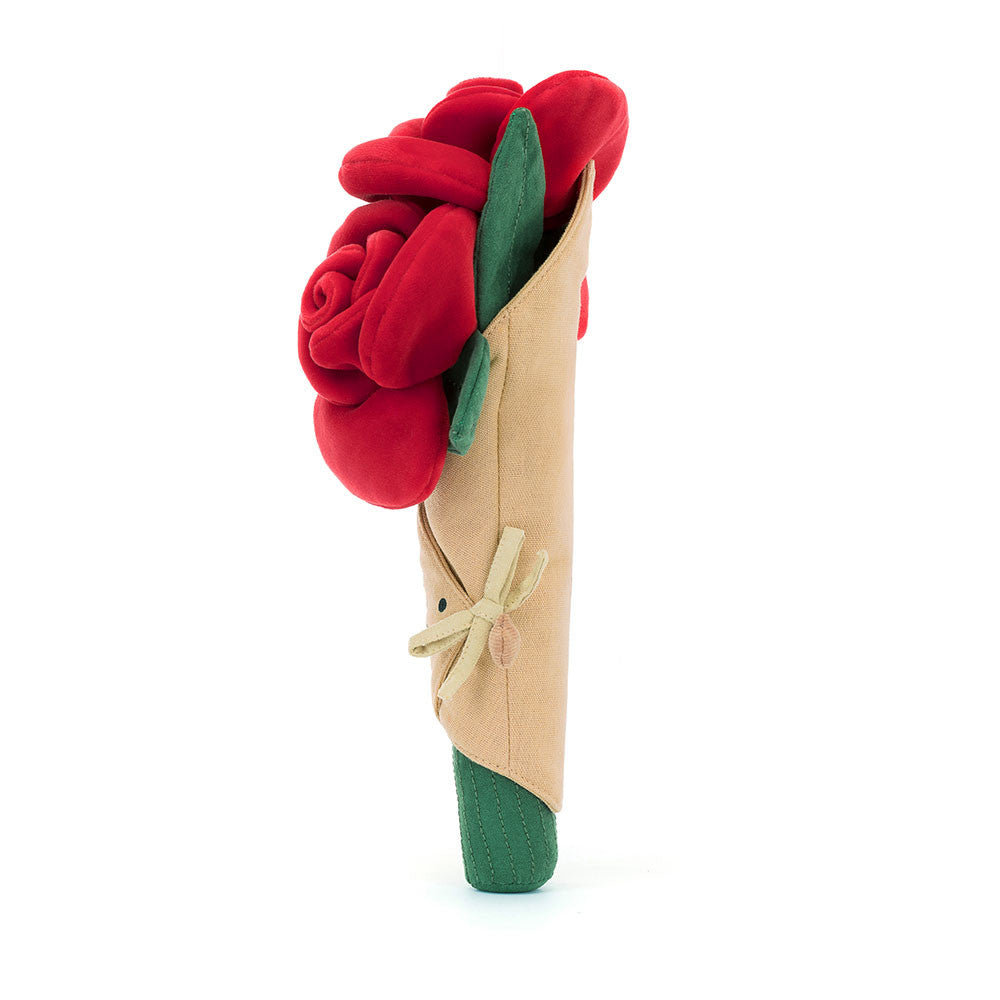 side view of plush toy of wrapped bouquet of red roses with smiling face on white background