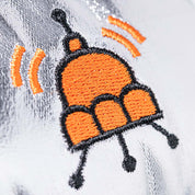 detail close up of orange spaceship shaped jellycat logo stitched on silver fabric