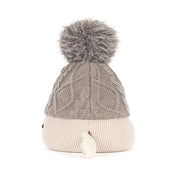 sideview of A plush toy toque by jellycat with a gray cable-knit top, a cream ribbed bottom, a gray pom-pom, and small fabric hands and feet, shown on a white background.