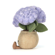 Plush toy purple hydrangea flower with green leaves in a beige pot on a white background