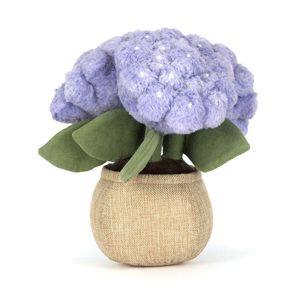 plush toy flower with purple flowers and green leaves in a beige pot on a white background