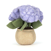 plush toy flower with purple flowers and green leaves in a beige pot on a white background