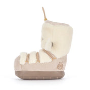 sideview of A plush boot-shaped jellycat brand plush toy with a cream sherpa upper, beige corduroy-like lower section, and a tan hanging loop at the top, shown on a plain white background.