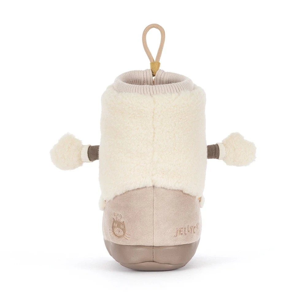 backview of A plush boot-shaped jellycat brand plush toy with a cream sherpa upper, beige corduroy-like lower section, and a tan hanging loop at the top, shown on a plain white background.