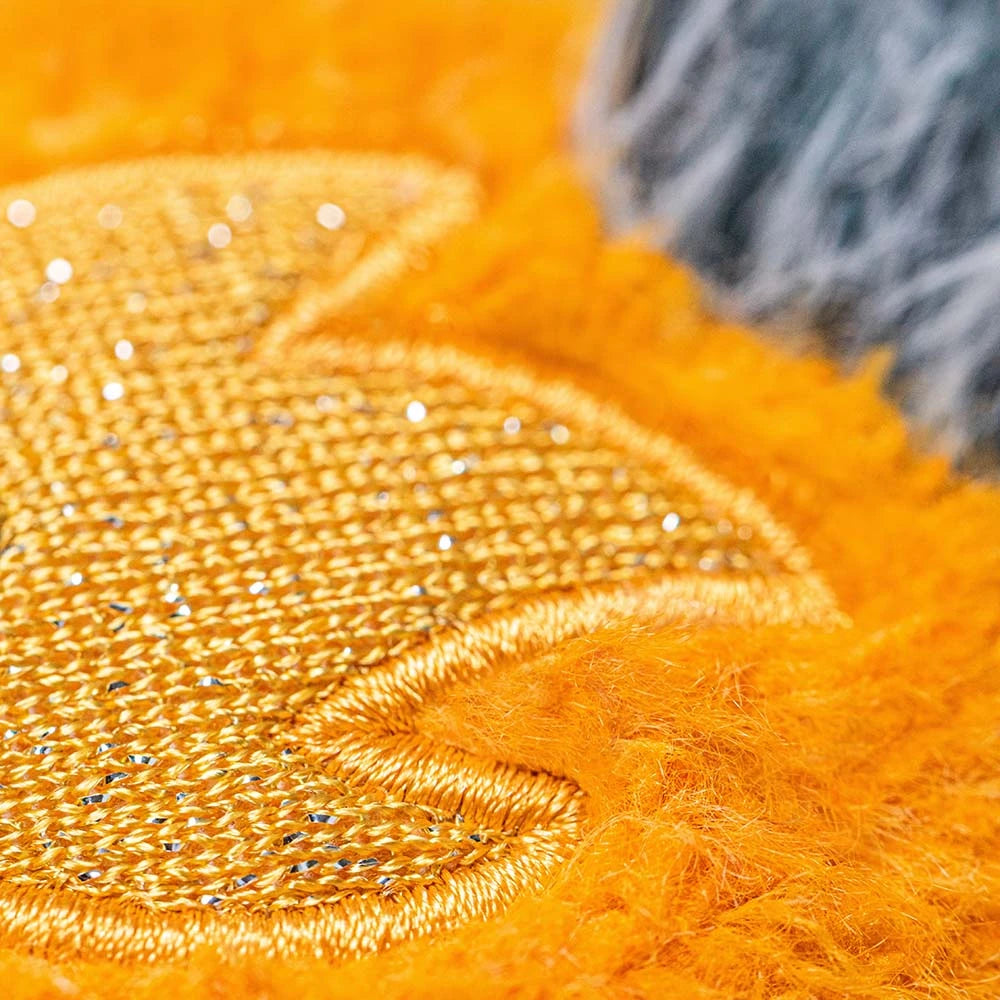 Close-up of orange fabric with textured pattern and sequins.