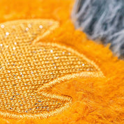 Close-up of orange fabric with textured pattern and sequins.