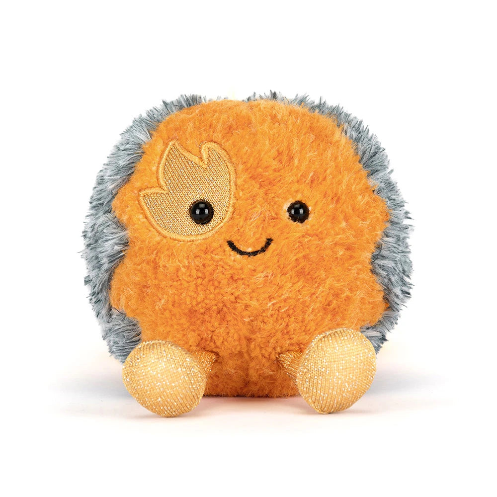 close up on smiling face of orange and grey space comet plush toy on white background