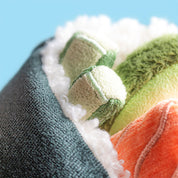 close up of Plush jellycat toy shaped like a sushi roll with black exterior, pink and green fillings on a white background
