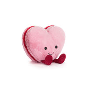 Pink Heart-shaped plush toy macaron with a smiling face on a white background