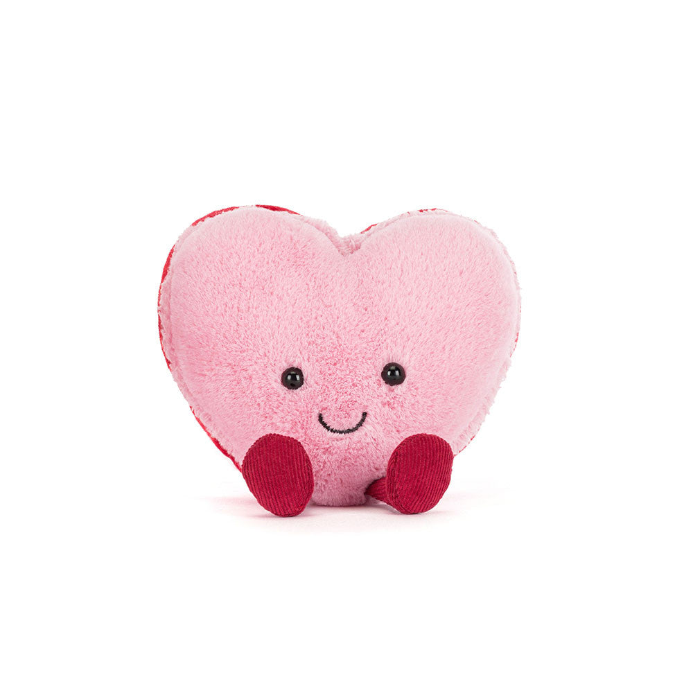Pink Heart-shaped plush toy macaron with a smiling face on a white background