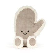 A plush winter mitten jellycat toy in a warm taupe-brown fabric with cream sherpa trim, featuring a simple embroidered smiley face and small feet, shown on a clean white background.