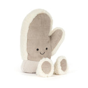 A plush winter mitten jellycat toy in a warm taupe-brown fabric with cream sherpa trim, featuring a simple embroidered smiley face and small feet, shown on a clean white background.
