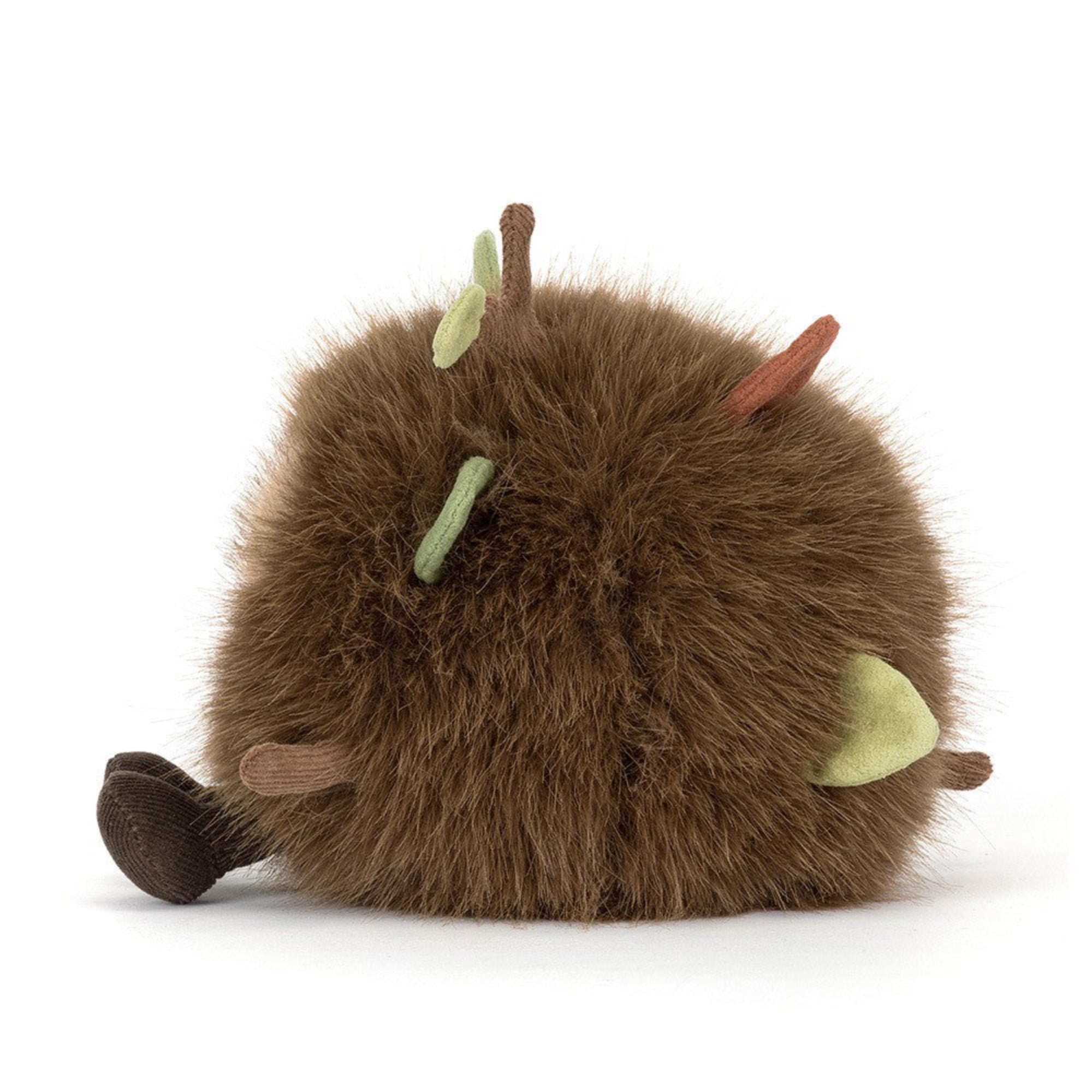 side view of jellycat forest floor with fuzzy fur and leaves and sticks and cute face and legs on white background
