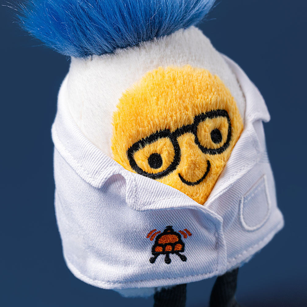 detail shot of smiling boiled egg plush toy with black rim glasses, blue hair and white scientist lab coat on blue background 