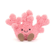 Pink jellycat plush coral toy with a smiling face on a white background
