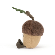 side view of Two jellycat plush acorns with faces and a branch on a white background