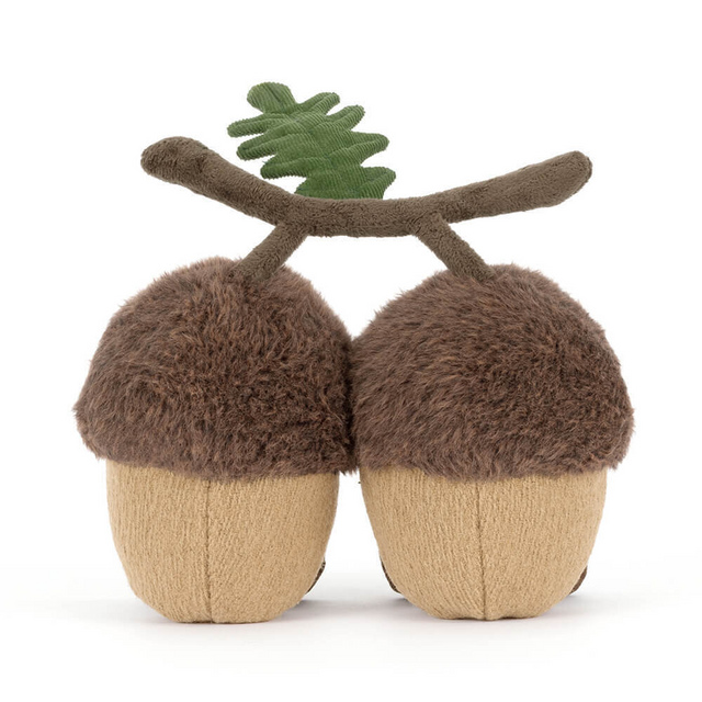 back view of Two jellycat plush acorns with faces and a branch on a white background