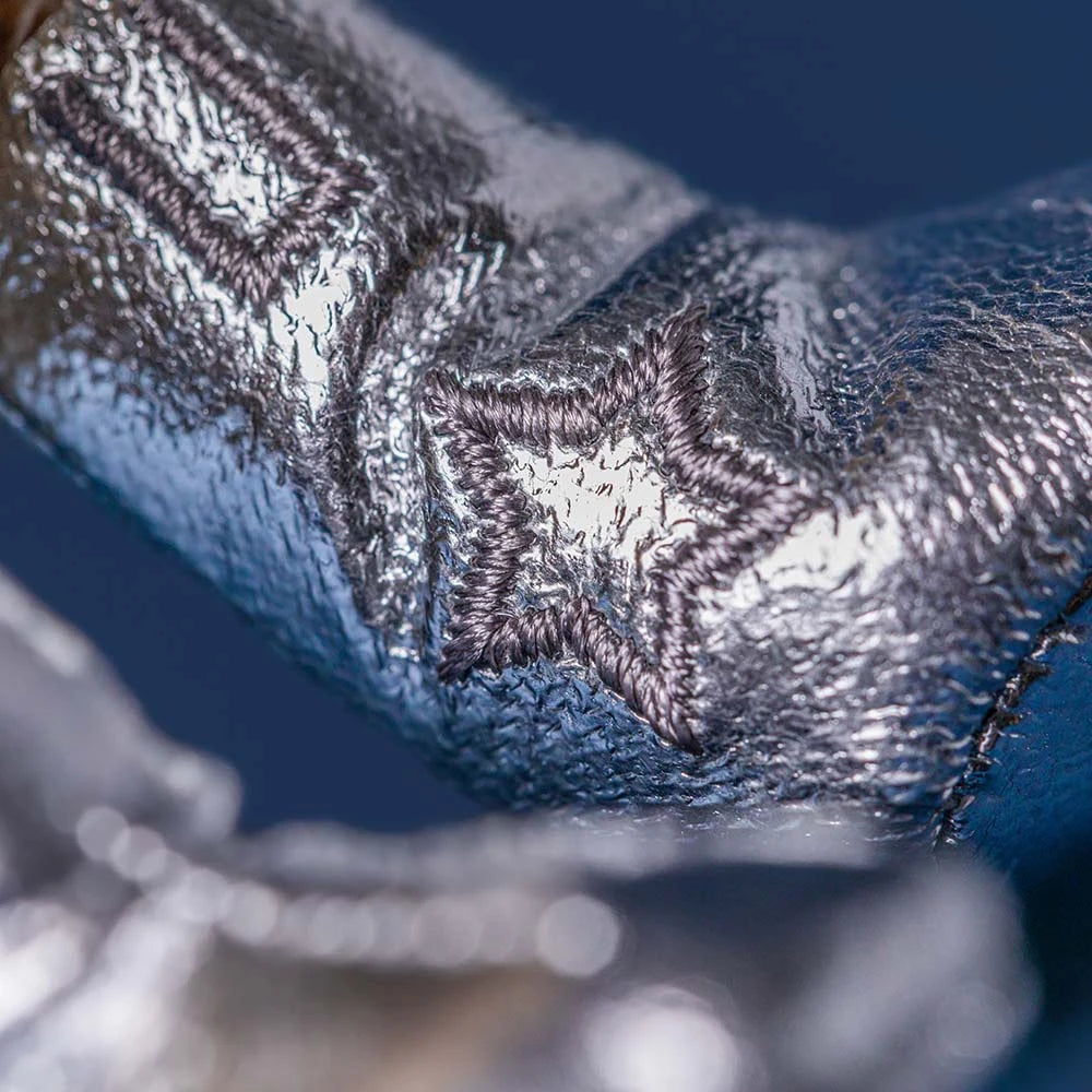 close up detail of shiny silver material with stitched star