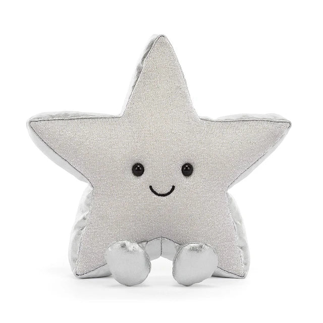 A silver glittery star-shaped jellycat brand plush toy with a smiling embroidered face and small feet, photographed on a clean white background.