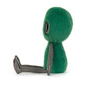 side view of plush green fur alien with black eyes and black silver limbs on a white background