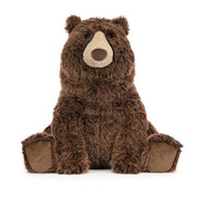A large jellycat brown plush stuffed bear toy sitting upright on a clean white background.