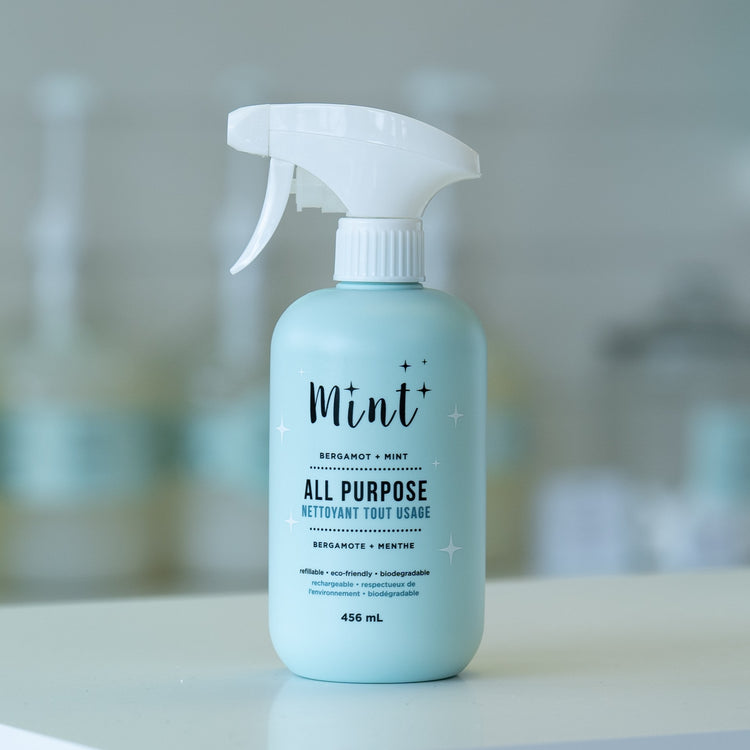 All-purpose cleaning spray bottle labeled 'Mint' on a blurred background
