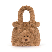 A brown teddy bear-shaped handbag made of curly, textured faux fur, featuring a small embroidered face and roundnded top handles, shown on a plain white background.