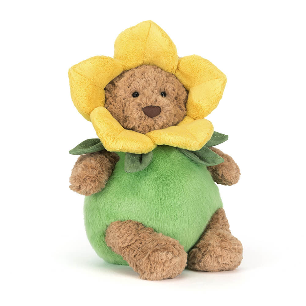 Plush brown bear in green and yellow daffodil flower outfit on white background