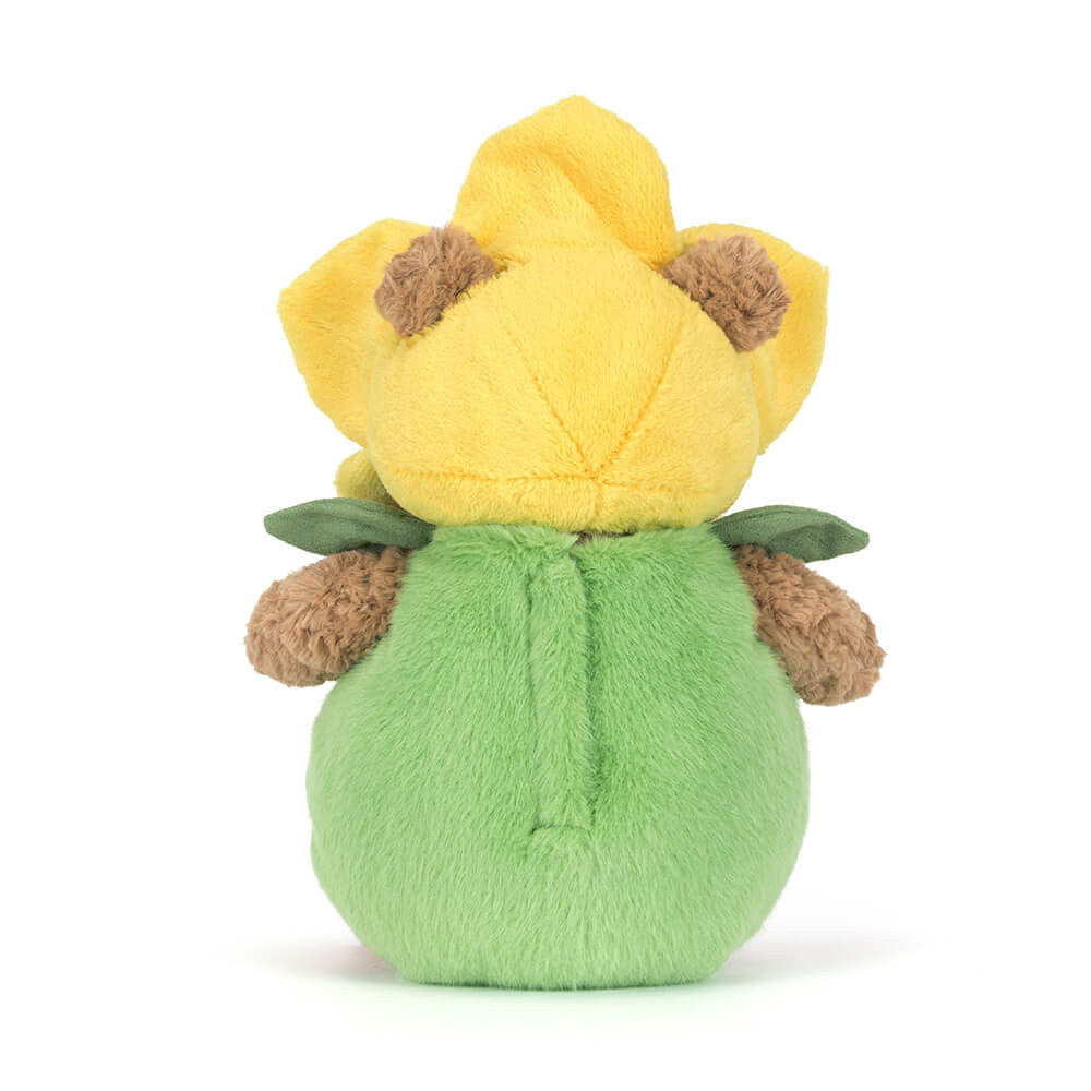 Plush brown bear in green and yellow daffodil flower outfit on white background