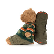 side view of Jellycat Bartholomew Bear in hiking outfit with leaf sweater and sleeping bag accessory on white background
