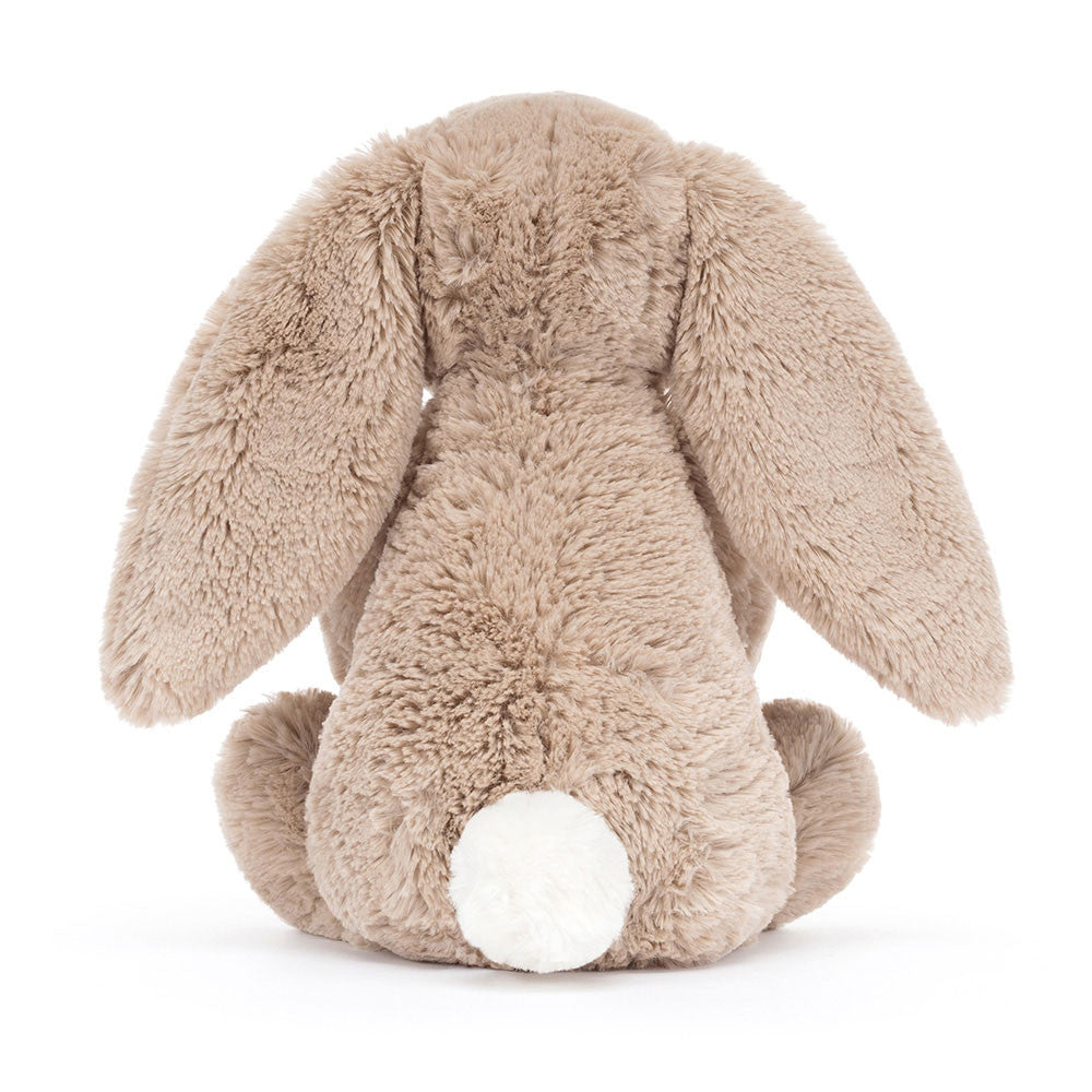 back view of a Plush jellycat bunny holding a birthday cake with a candle on a white background
