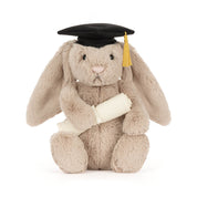 Plush toy rabbit wearing a graduation cap and holding a diploma on a white background