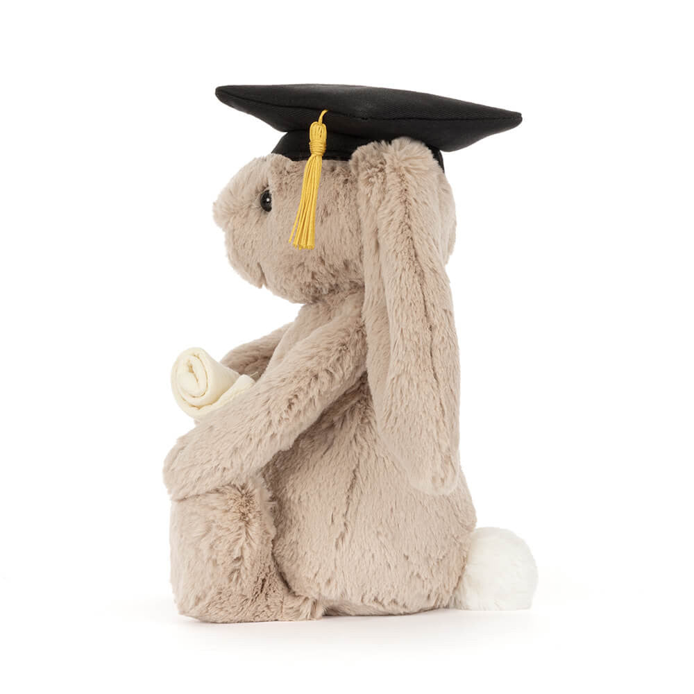 Plush toy rabbit wearing a graduation cap on a white background