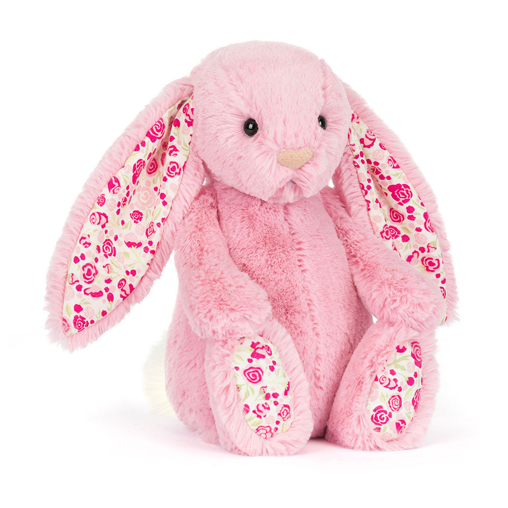 Pink plush bunny with floral patterns in ears and on feet on a white background
