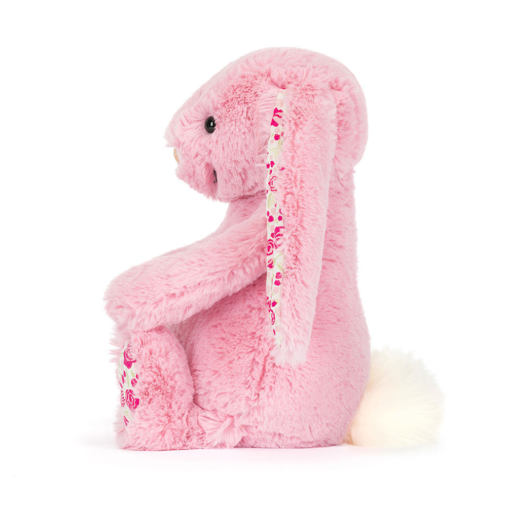 Pink plush bunny toy with floral pattern in ears on a white background