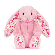 pink plush bunny toy with floral pattern in ears and on feet on white background