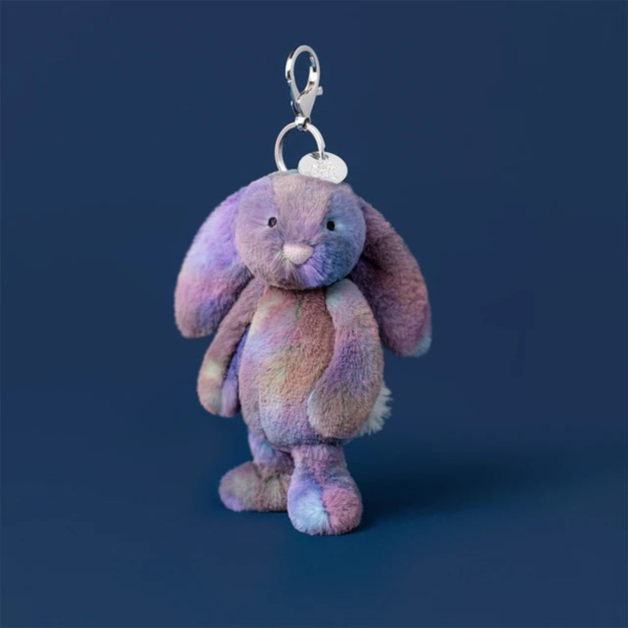 Multicolored galaxy colours Jellycat bunny keychain on a blue background