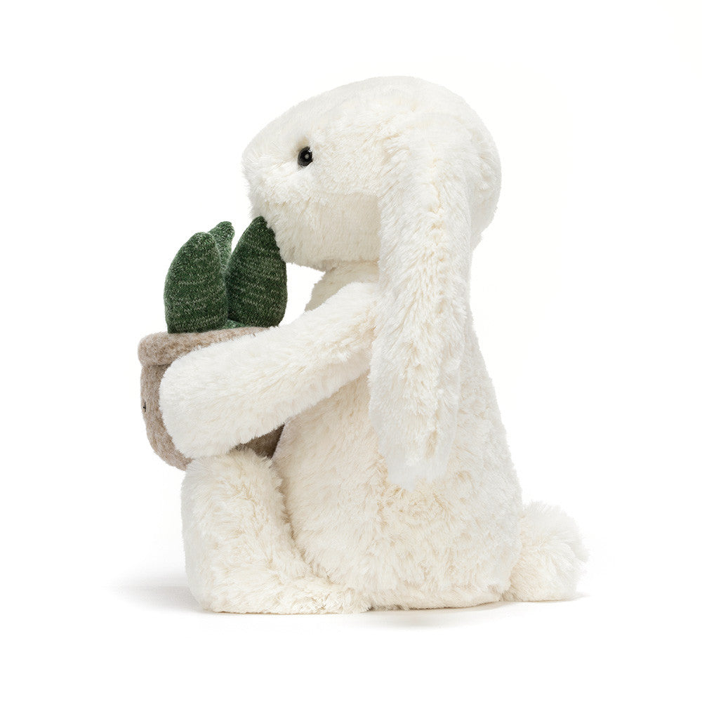 white bunny rabbit plush toy holding smiling potted plant on white background