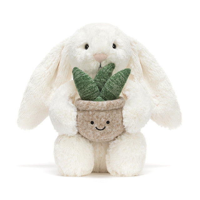 white bunny rabbit plush toy holding smiling potted plant on white background