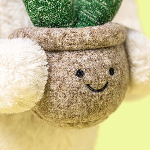 detail shot of smiling put held by plush bunny with yellow background