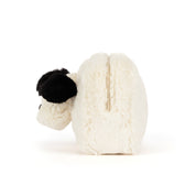 A plush zippered pouch in cream white faux fur with a black fluffy ear, shown from the side on a white background.