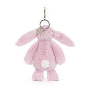 Pink plush bunny keychain with a tag on a white background