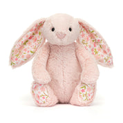 A plush jellycat blush-pink bunny with floral ears and feet with a cherry blossom print on a white background