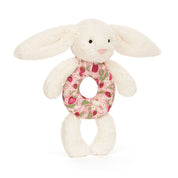 Plush bunny baby rattle toy from jellycat with a floral ring on a white background