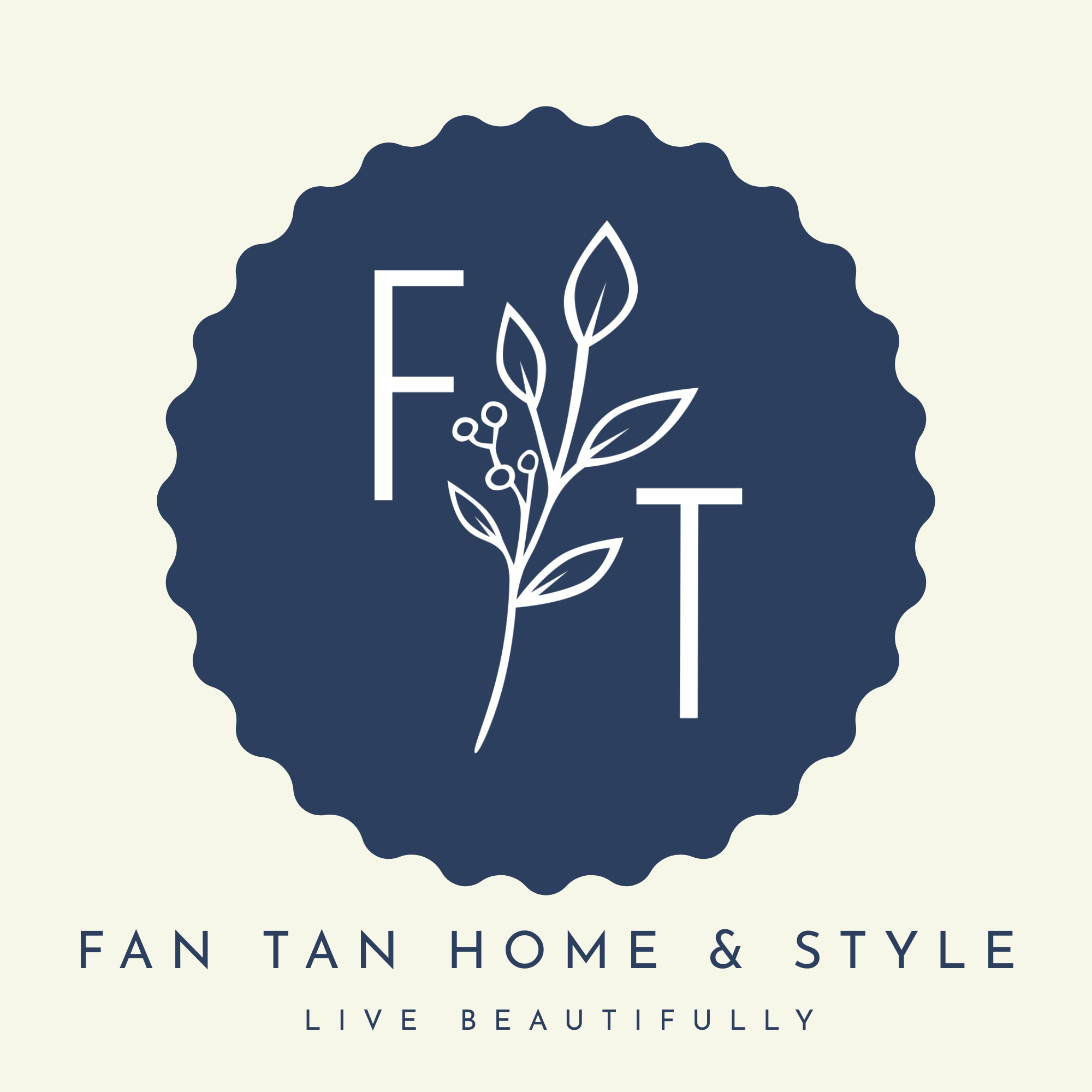 A circular navy blue badge with scalloped edges on a light cream background, featuring white stylized letters F and T and a leafy branch motif. Below the badge, the text reads 'FAN TAN HOME & STYLE' and 'LIVE BEAUTIFULLY' in navy blue.
