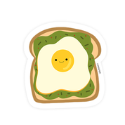 sticker of a smiling fried egg on top of avocado toast